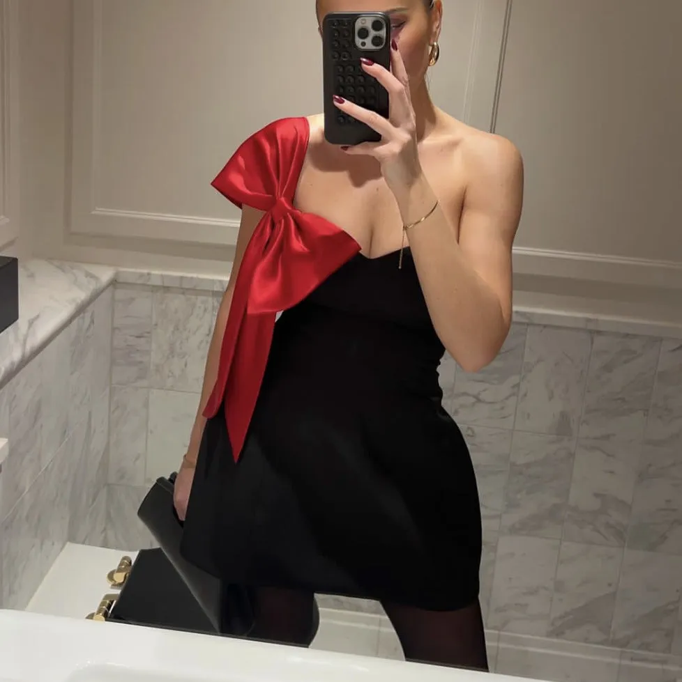 Elegant Off-Shoulder Dress with Dramatic Red Bow Accent